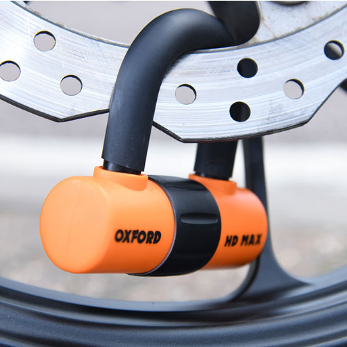 An Oxford HD max motorcycle disc lock pictured secured on a motorcycle front disc brake